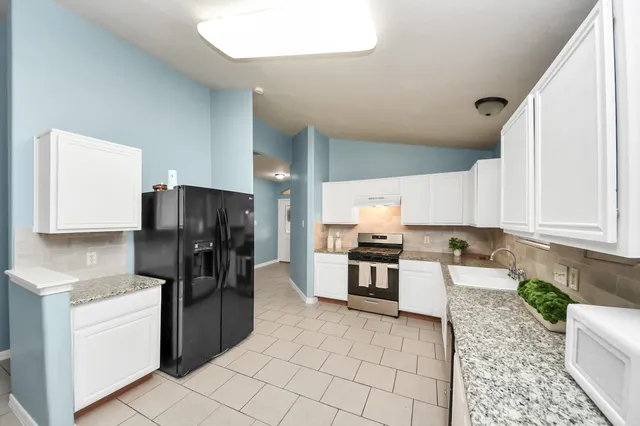 a living room with furniture a dining table and a refrigerator