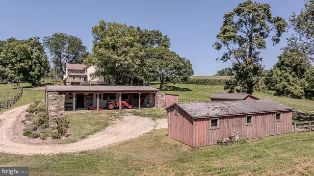 an aerial view of a residential houses with outdoor space and trees