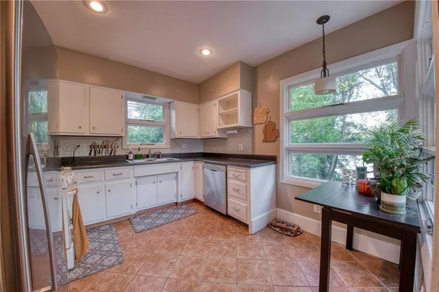 a kitchen with a refrigerator a sink and cabinets