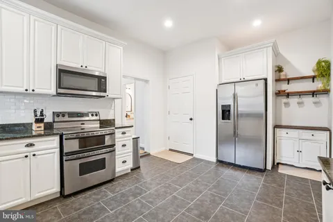 a kitchen with stainless steel appliances granite countertop a stove a refrigerator and a microwave