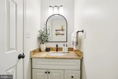 a bathroom with a granite countertop sink and a mirror