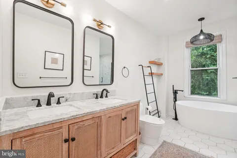 a bathroom with a double vanity sink a mirror and a bathtub