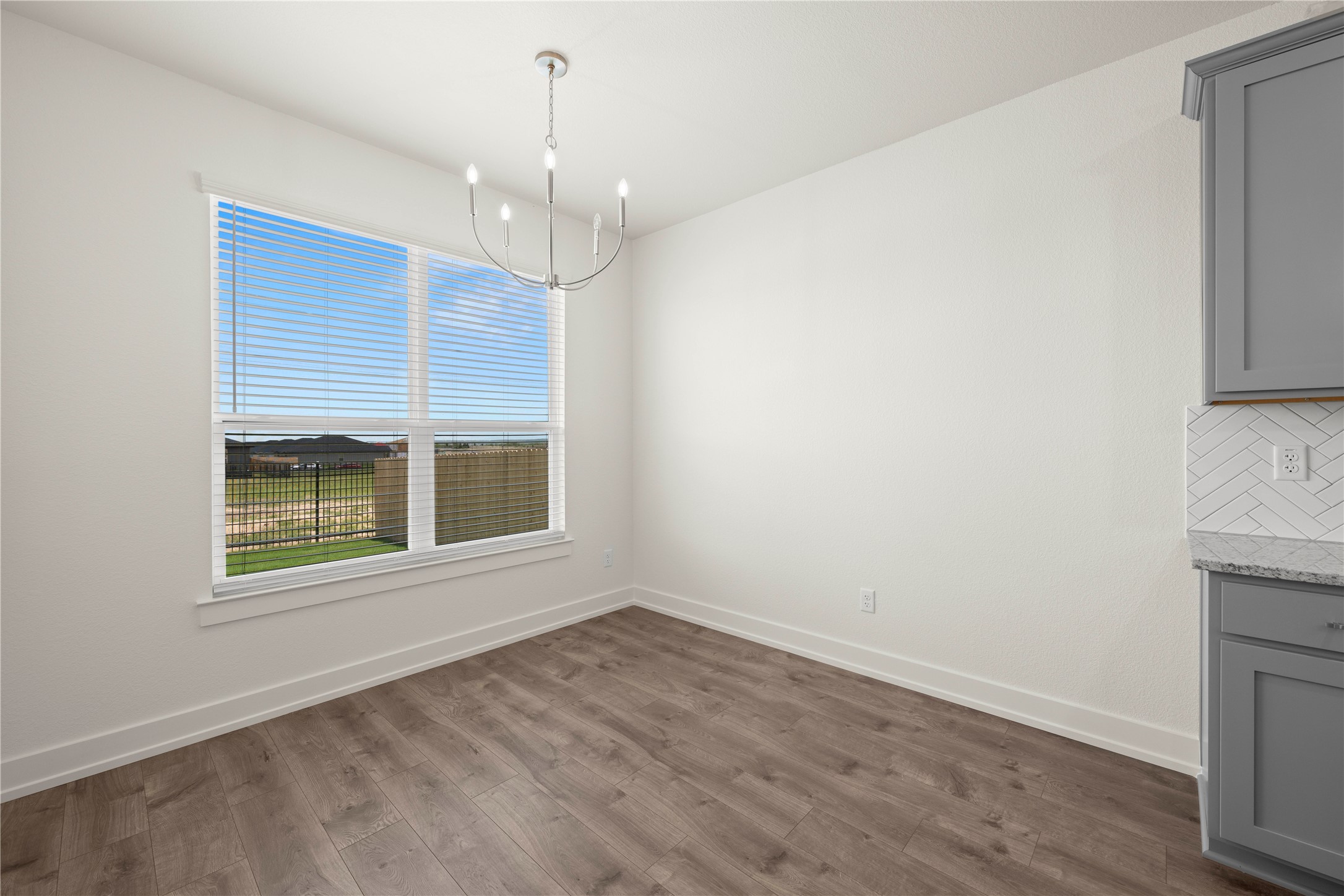 564 Gus Loop Georgetown, TX 78626 - Photo 7 of 32 an empty room with wooden floor and windows