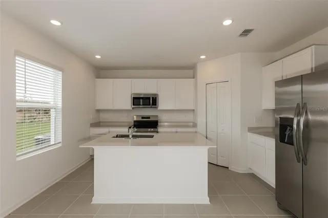 a kitchen with stainless steel appliances a refrigerator a stove a sink and a refrigerator