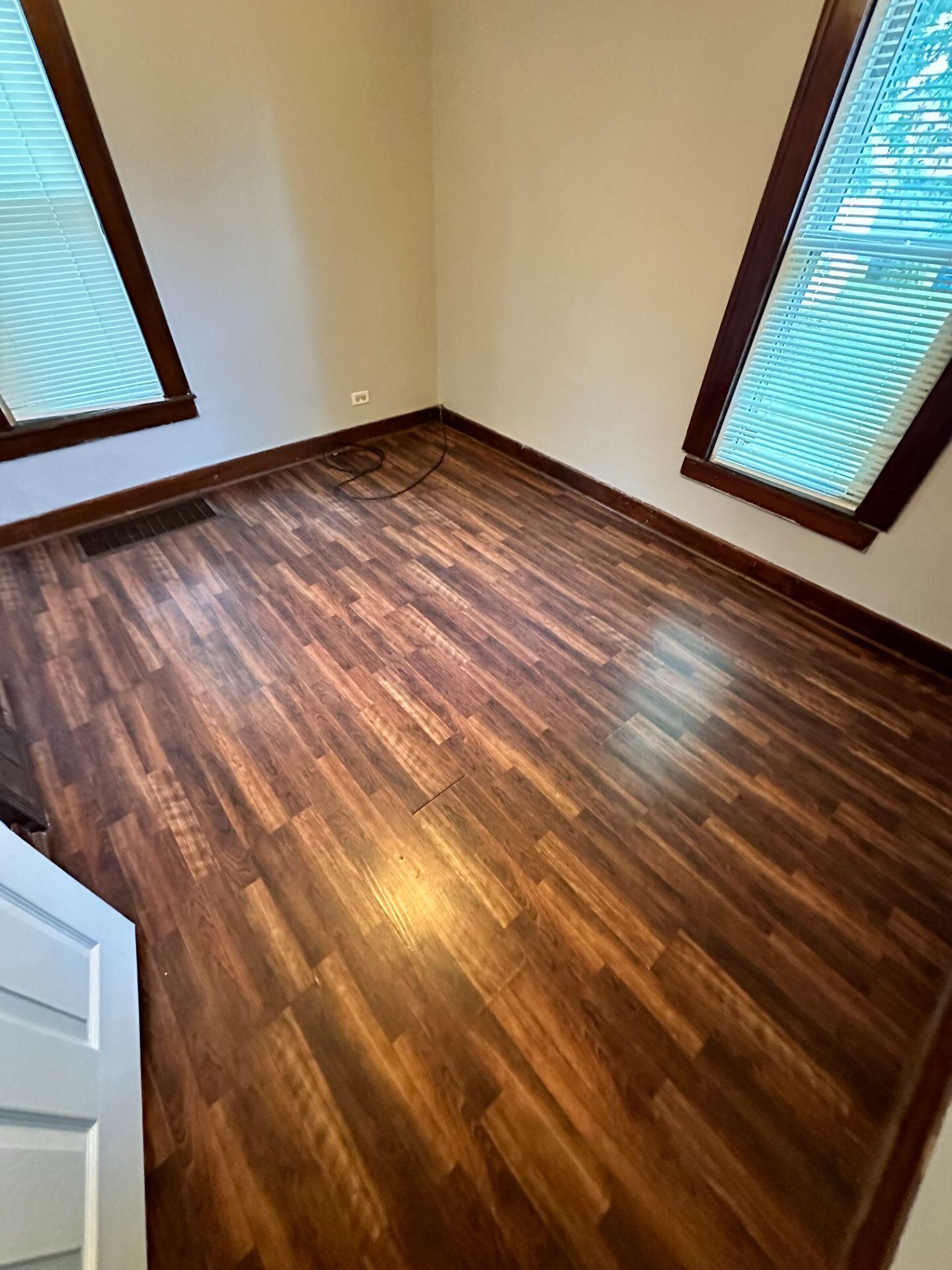 547 169th Street, Unit WEST Hammond, IN 46324 - Photo 5 of 7 a view of an empty room with wooden floor and a window