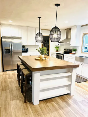 a kitchen with stainless steel appliances granite countertop a stove and a wooden floors