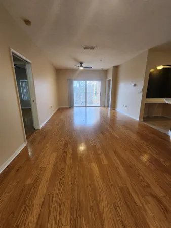 a view of empty room with wooden floor