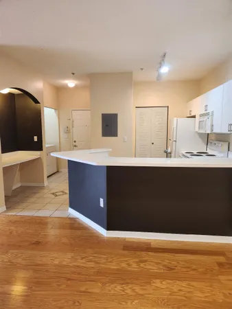 a kitchen with a sink a large mirror and cabinets