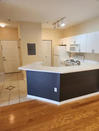 a kitchen with stainless steel appliances kitchen island granite countertop a stove a sink and a refrigerator