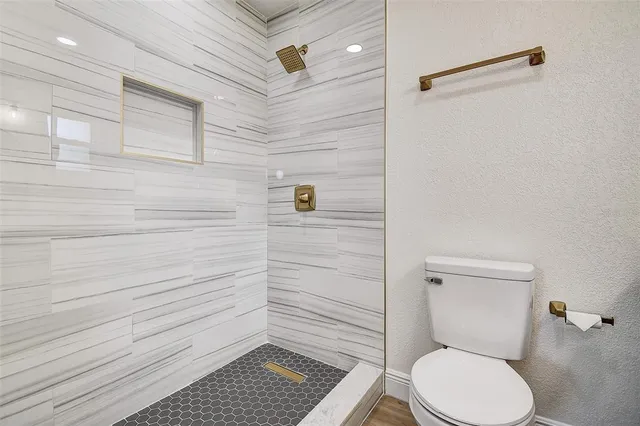 a bathroom with a toilet and a shower