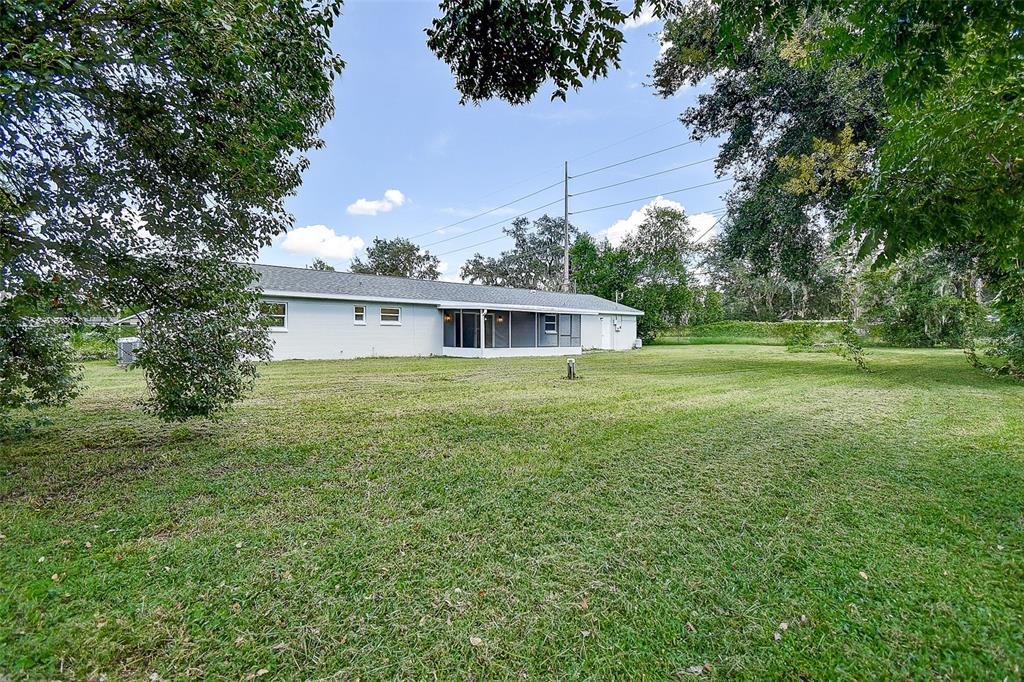 2015 Capri Road Valrico, FL 33594 - Photo 28 of 34 a white house with a big yard and large trees