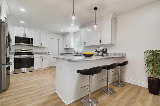 a kitchen with a sink a counter top space appliances and cabinets