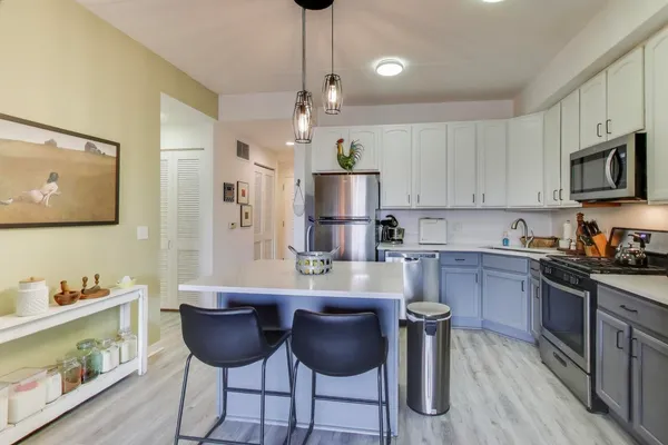 a kitchen with cabinets a center island and appliances