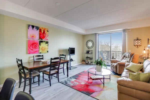 a living room with furniture kitchen view and a wooden floor