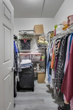 a view of walk in closet with clothes and shoes