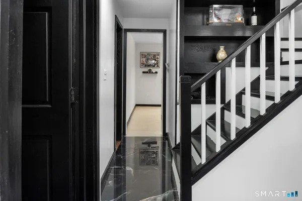 a view of staircase with lots of frames on wall and wooden floor