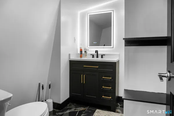 a bathroom with a toilet sink and mirror