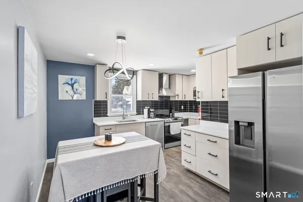 a kitchen with refrigerator cabinets dining table and chairs