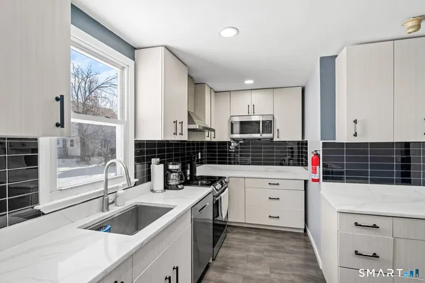 a kitchen with stainless steel appliances kitchen island granite countertop a sink and cabinets