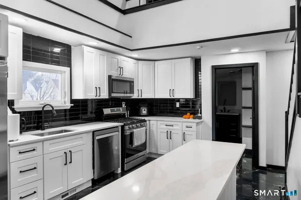 a kitchen with white cabinets and appliances