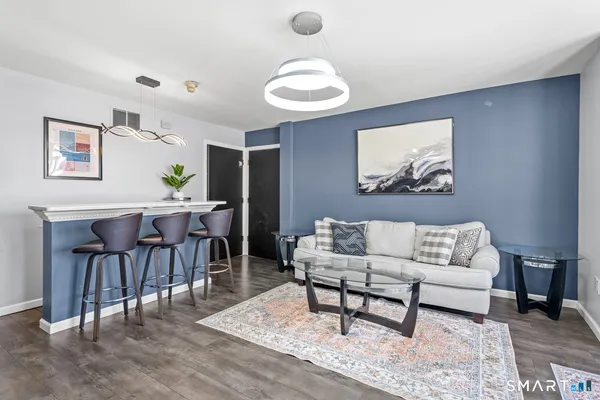 a living room with furniture a dining table and paintings on the wall