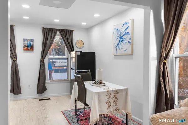 a living room with furniture a flat screen tv and a refrigerator