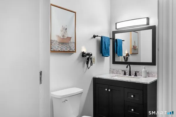 a bathroom with a toilet sink vanity and mirror