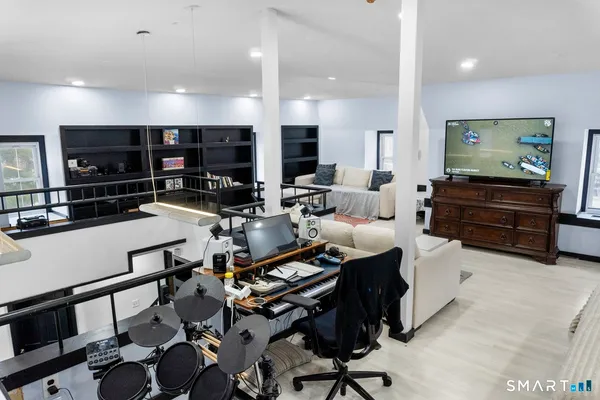 a living room with furniture a flat screen tv and kitchen view