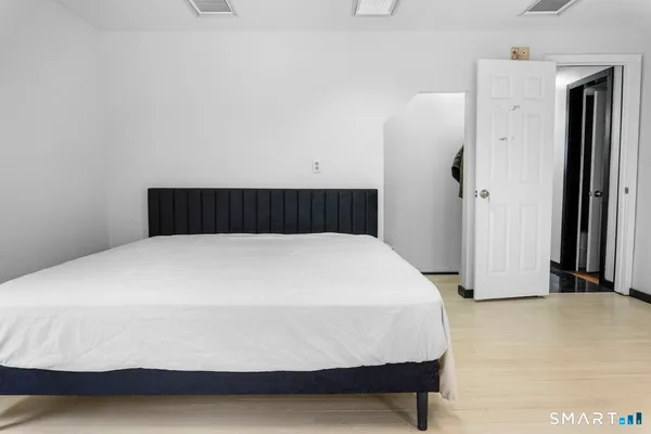 a bedroom with a bed and wooden floor