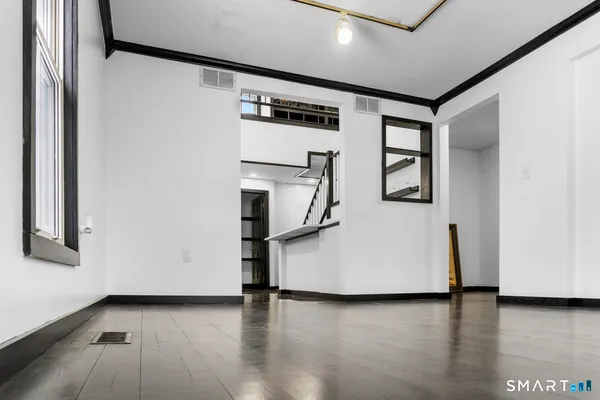 a view of a livingroom with wooden floor and stairs