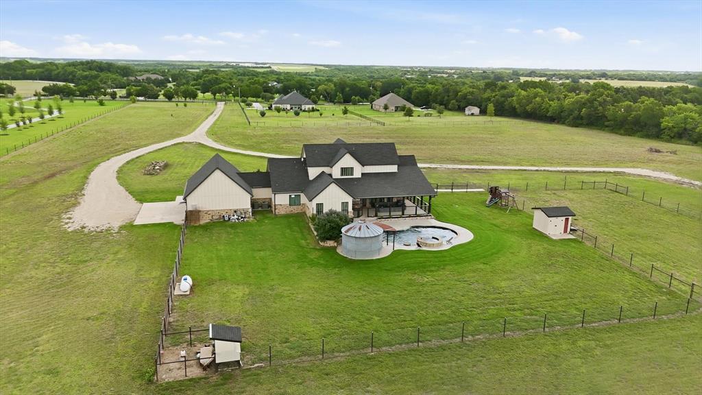 6020 Honeysuckle Road Midlothian, TX 76065 - Photo 3 of 39 Expansive property featuring a multi-gable residence with an attached covered patio, a fenced backyard with an in-ground pool, and a gravel driveway