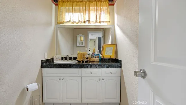 a bathroom with a granite countertop sink and a mirror