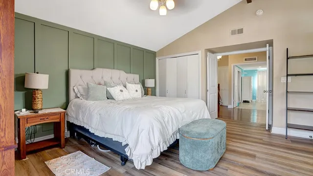 a bedroom with a balcony a bed and wooden floor