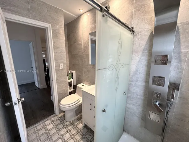 a bathroom with a granite countertop toilet a sink and a shower