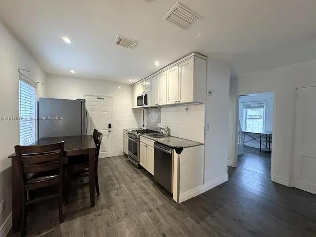 a kitchen with stainless steel appliances a stove top oven and a refrigerator