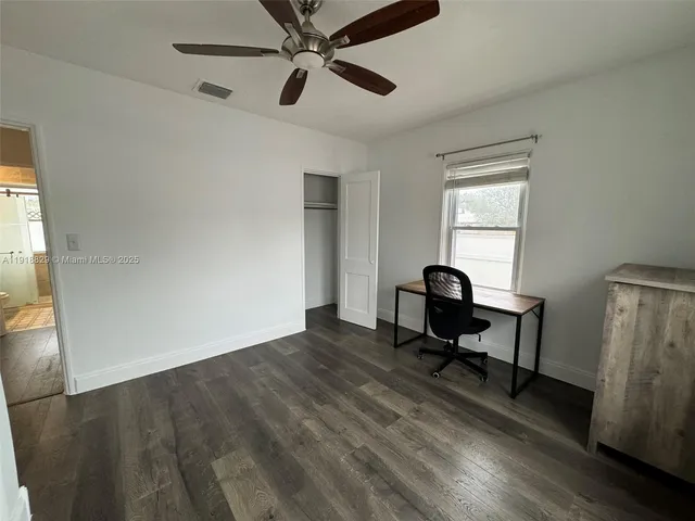 a workspace with wooden floor and a window