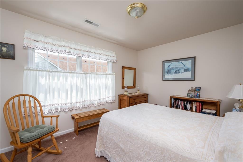 192 Wood Hawk Lane Butler, PA 16001 - Photo 19 of 23 a bedroom with a bed a large window and a chandelier