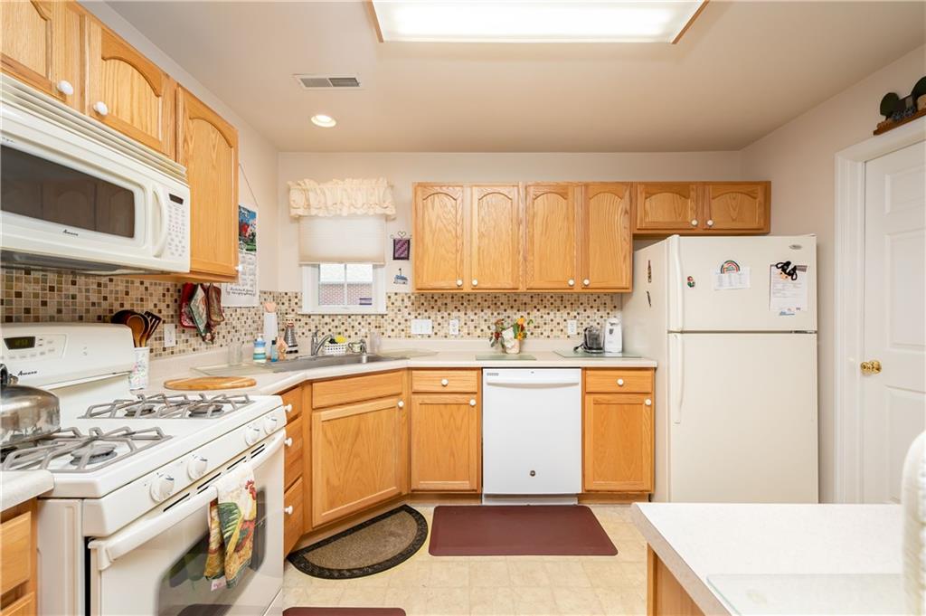192 Wood Hawk Lane Butler, PA 16001 - Photo 6 of 23 a kitchen with stainless steel appliances granite countertop a refrigerator a stove a sink and white cabinets with wooden floor