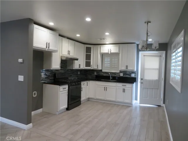 a view of kitchen with refrigerator sink and cabinets