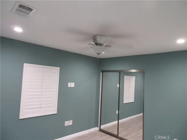 an empty room with a window and ceiling fan