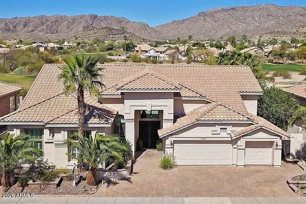 an aerial view of a house with a mountain