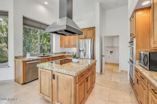 a view of a kitchen with refrigerator and a stove top oven