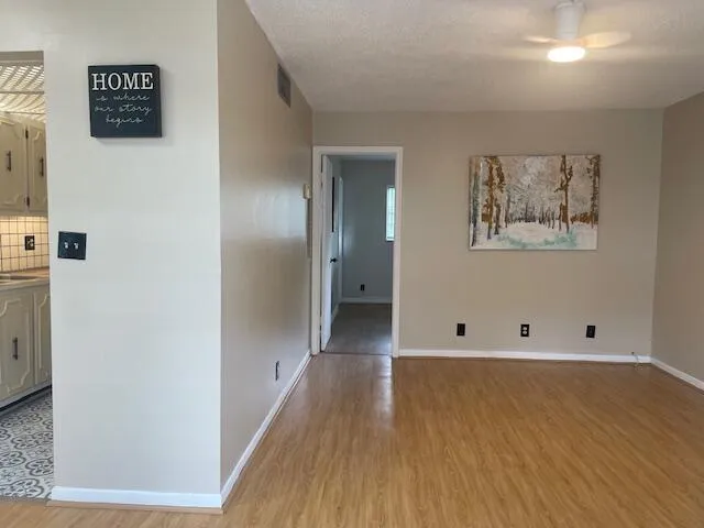 a view of an empty room with wooden floor