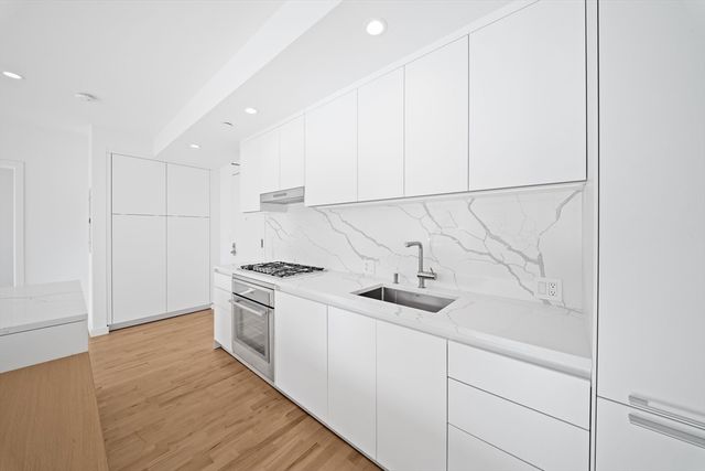 a kitchen with stainless steel appliances granite countertop a sink a stove and a refrigerator