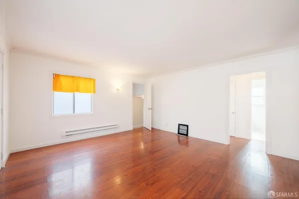 a view of an empty room with wooden floor
