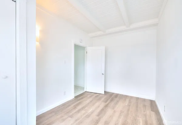 a kitchen with white cabinets appliances and a window