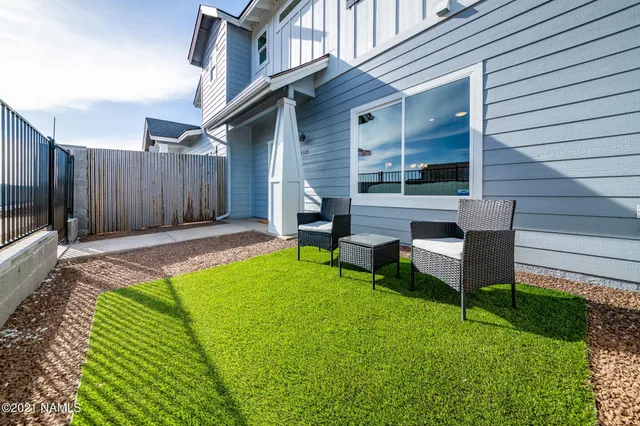 a view of house with backyard and a sitting area
