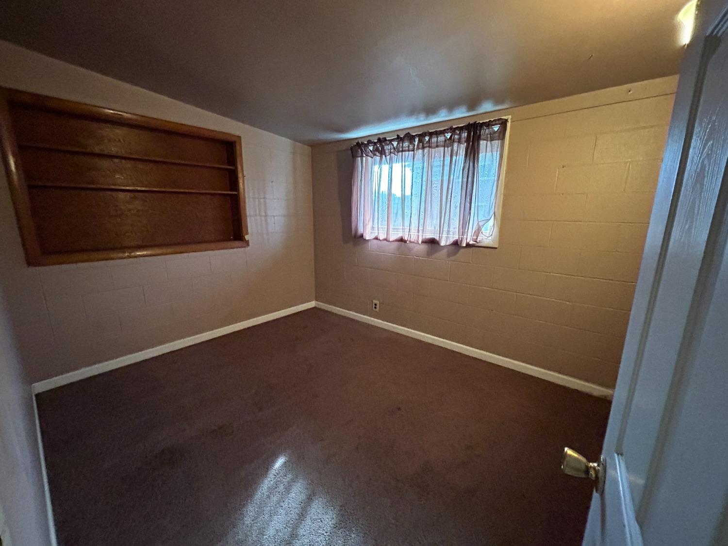 236 K Street Sanger, CA 93657 - Photo 11 of 23 a view of an empty room with wooden floor and a window