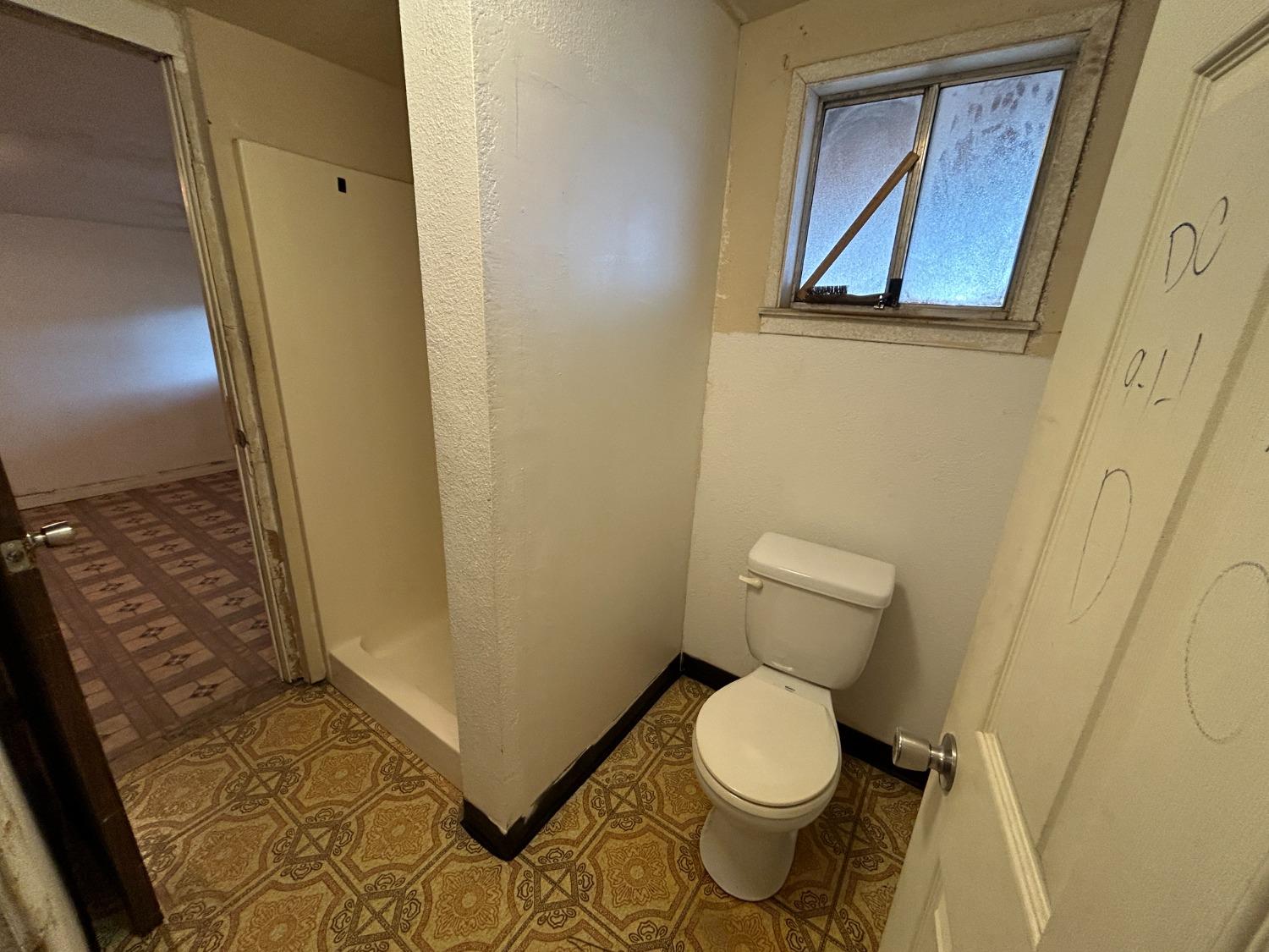 236 K Street Sanger, CA 93657 - Photo 17 of 23 a white toilet sitting next to a shower curtain