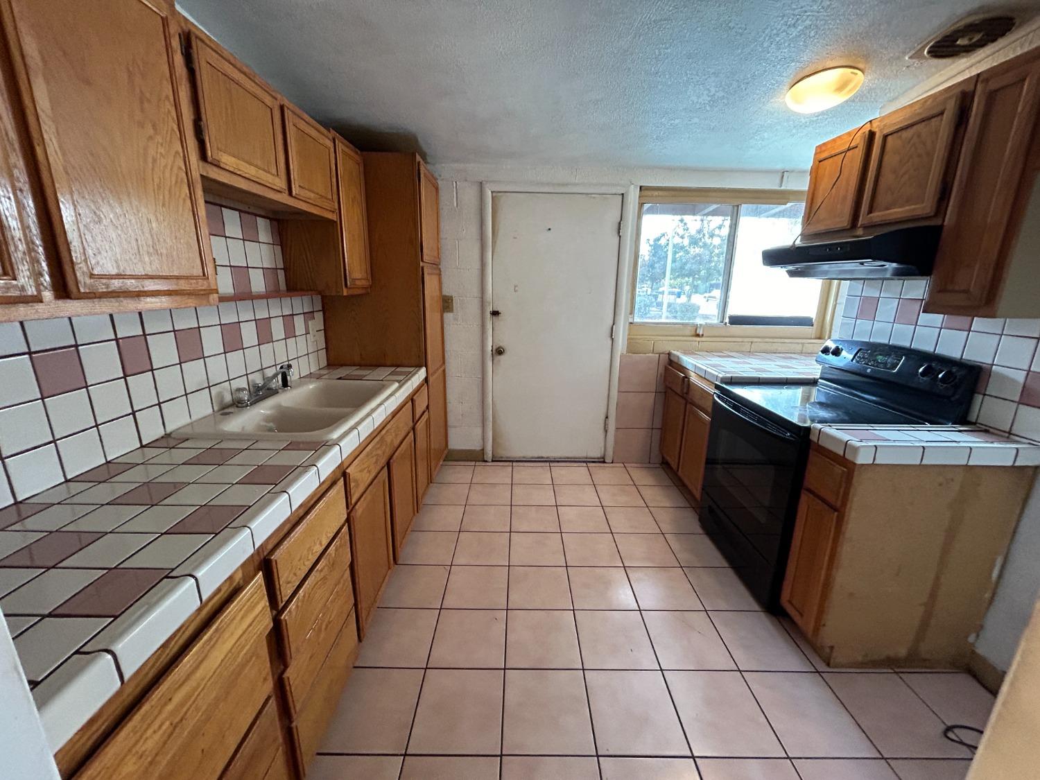 236 K Street Sanger, CA 93657 - Photo 3 of 23 a kitchen with stainless steel appliances granite countertop a stove a sink and a microwave